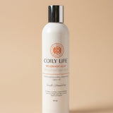 Coily Life shampoo bottle on a gray surface with a white background